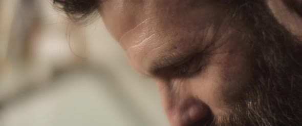 Close up of a bearded hispanic chef smiling wile working in the kitchen. Slow motion.