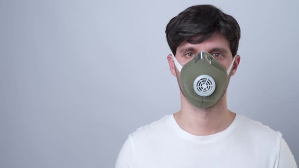 Man in a Respiratory Mask, Isolated on a Gray Background