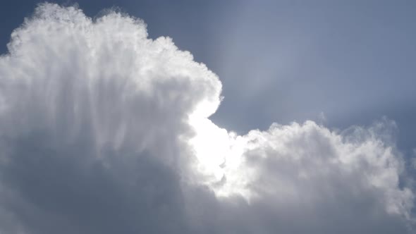 Dramatic sky with sunbeams shining through cloud. Static, low angle