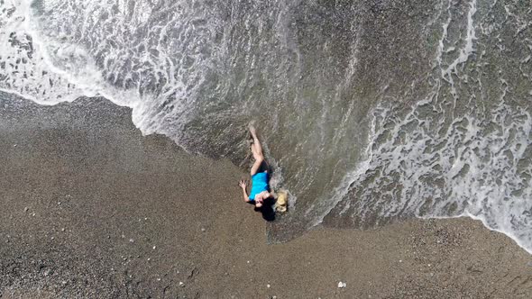 A Woman Enjoys Waves on a Sandy Beach