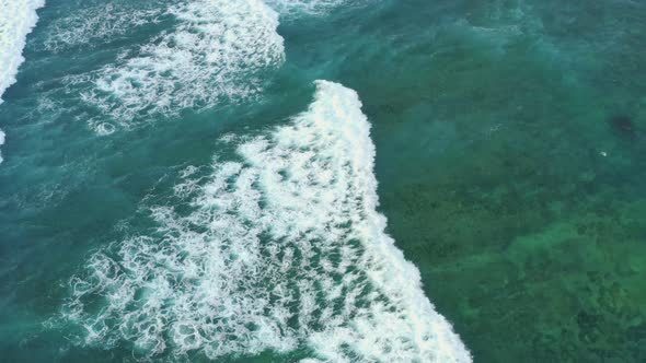 Aerial Top Down View of Giant Ocean Waves Crashing and Foaming