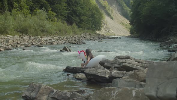 Cheerful Charming Asian Woman in Swimsuit Having Fun Floating on Big Inflatable Ring in Mountain