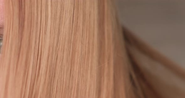 Woman combing her long hair close up