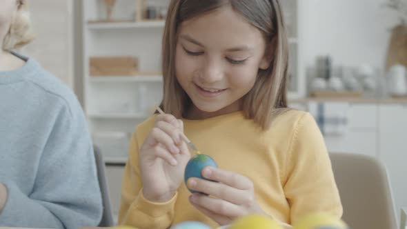 Girl and Grandmother Decorating Easter Eggs