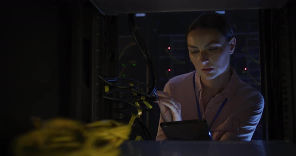 Caucasian female it technician using tablet checking computer server