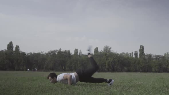 Wide Shot of Young Break Dancer Dancing on Green Summer Meadow