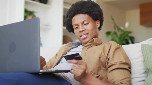 African american man using laptop at home