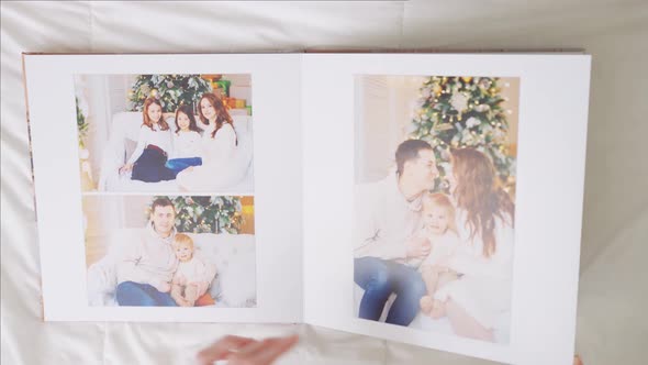 Hands Scroll Through Pages of Photobook on White Background