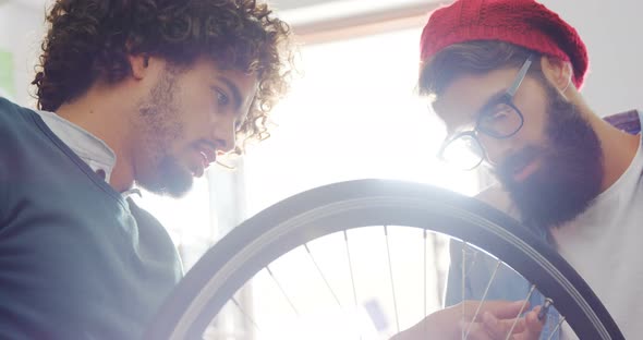 Mechanics repairing bicycle in workshop