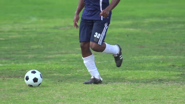 A man playing soccer on a grassy field