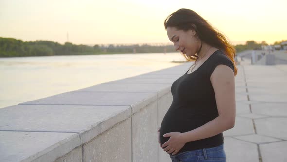 Maternity and Pregnancy Concept. Young Happy Pregnant Woman in the Sunset