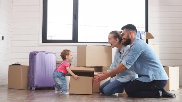 Small Child Is Holding a Small Box. Parents Are Waiting for a Child with a Box.