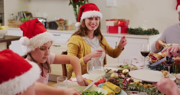 Caucasian girl passing food plate to her mother