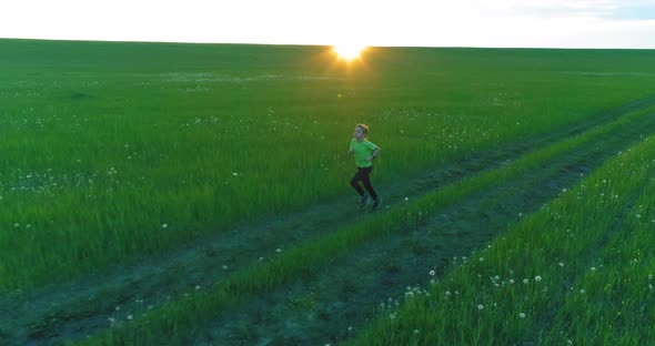 Sporty Child Runs Through a Green Wheat Field