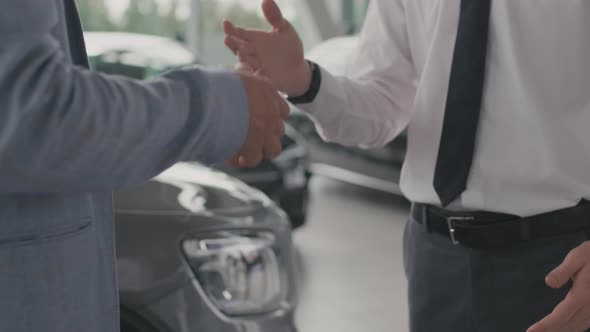 Customer and Car Salesman Shaking Hands in Dealership