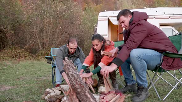 Couple and Their Close Friend Preparing Camp Fire