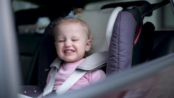 Little girl in a car seat. The window closes and the car leaves