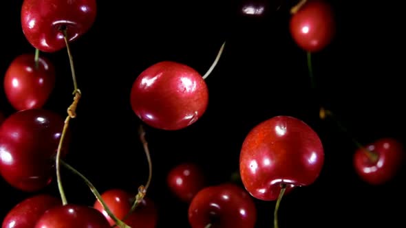 Close-up Of Cherries Bouncing On Black Background