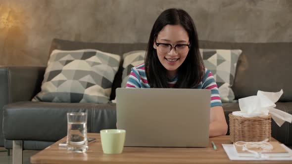 Asian woman using laptop for work from home and online learning.