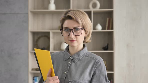 Serious Lady with Short Fair Hair and Glasses Looks Straight
