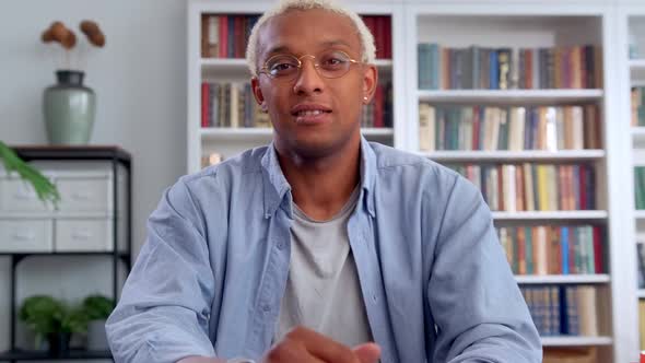 Young African American Man Looking at Camera with Smile Sits in Own Office