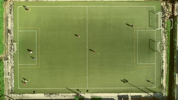 Aerial view of people training football in a beautiful football camp.