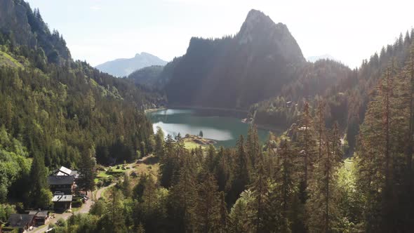 Jib down stunning lake and beautiful mountainside in background behind pine trees