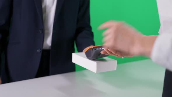 Anonymous Man in a Suit Makes a Payment with Credit Card and Buys a Smartphone in a White Box NFC