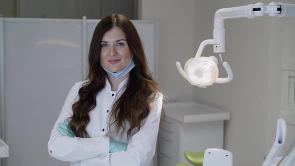 Successful Female Dentist Looking and Smiling at Camera with Crossed Hands