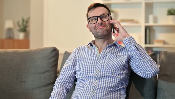 Young Man Talking on Smartphone at Home 