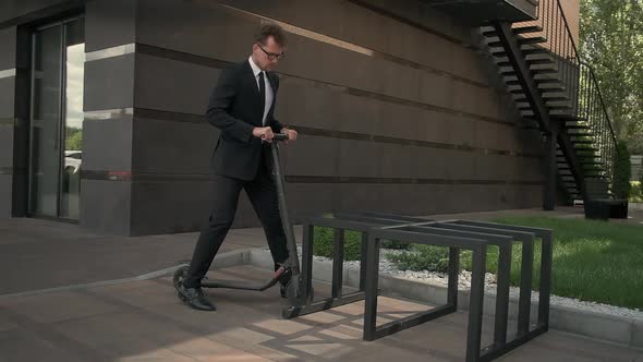 Businessman Is Parking Scooter Near Office Center