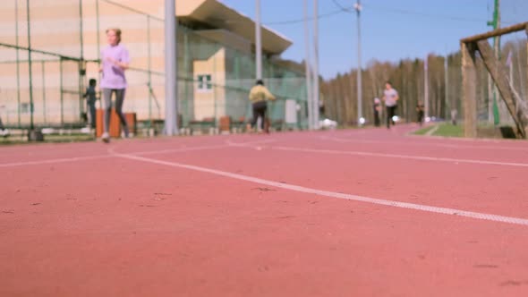 A woman runs on a outdoor treadmill.