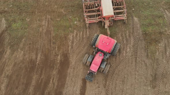 Tractor with a Sowing Unit Enters the Field for Processing Farmland