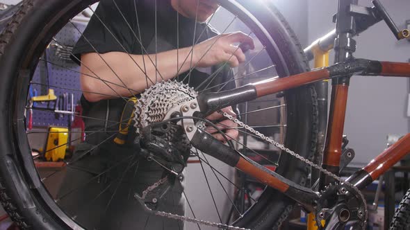 Bicycle Service Concept. A Young Man Repairs and Maintains a Bicycle