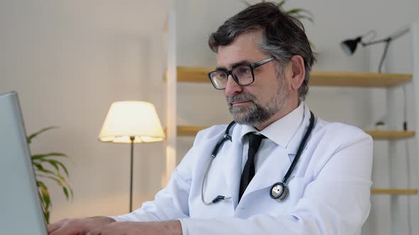 Senior Doctor 50s Works in Laptop