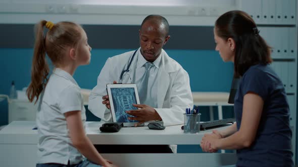 General Practitioner Showing x Ray Diagnosis on Tablet