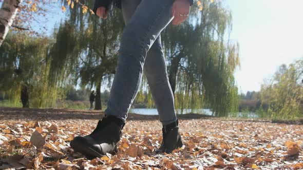 Female Legs Walking on Fallen Autumn Leaves in the Park in Slow Motion