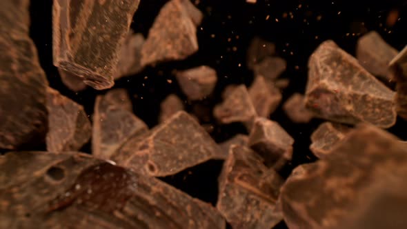 Super Slow Motion Detail Shot of Falling Raw Chocolate Chunks on Black Background at 1000Fps