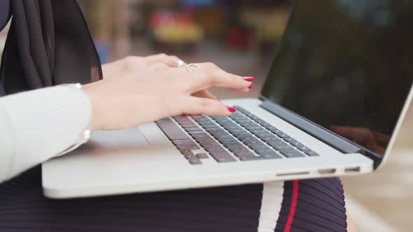 Close Up Of A Woman's Hands As She Types On Her Laptop Whilst Being Sat Outside