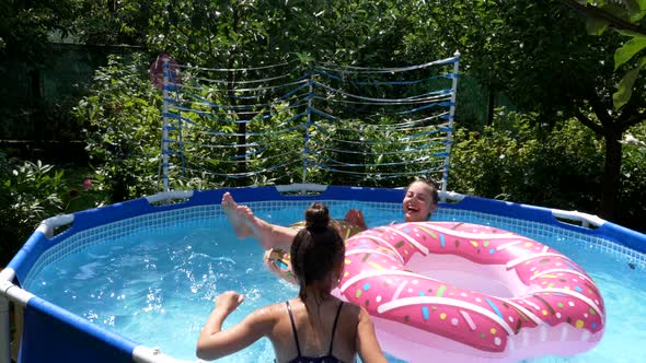 Happy Girls Have Fun Chilling and Floating on Donut Floats in Swimming Pool in Summer Floatation