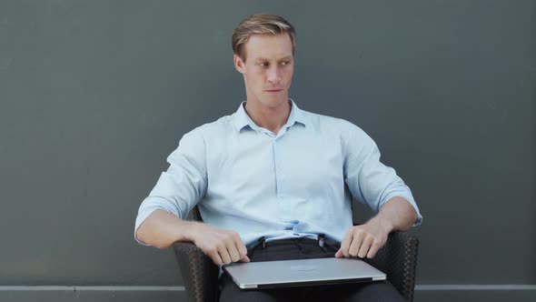 Strong Guy in White Classic Shirt Closes Laptop with Anger