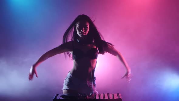 Girl DJ Starts Dancing Blue Pink Lights and a Lot of Smoke. Silhouette