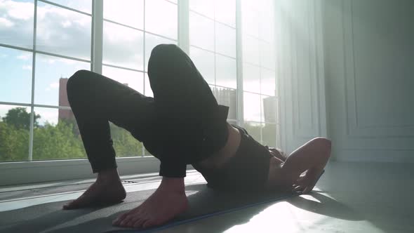 Calmness Young Man Doing Yoga in a White Room Filled with Light Man Does Stretching of Muscles Near