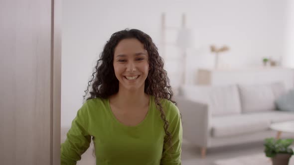 Cheerful Female Opening Door And Talking Standing At Home