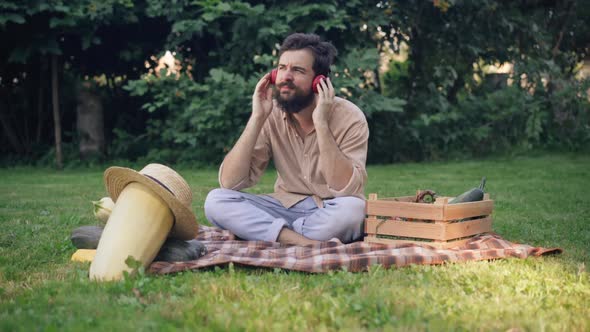 Wide Shot Portrait of Happy Satisfied Male Farmer Putting on Headphones Enjoying Music Having Break