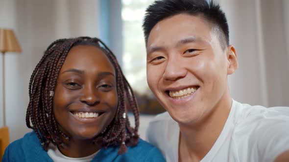 Multiethnic Smiling Couple Taking Selfie on Smartphone While Spending Time Together at Home