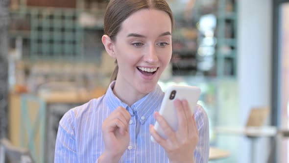 Portrait of Young Businesswoman Celebrating on Smartphone