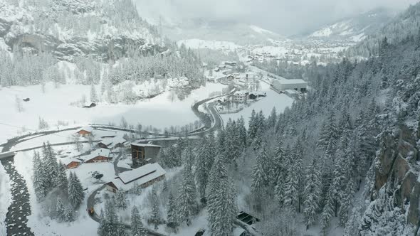 Aerial of distant Swiss town in snowy weather in winter landscape