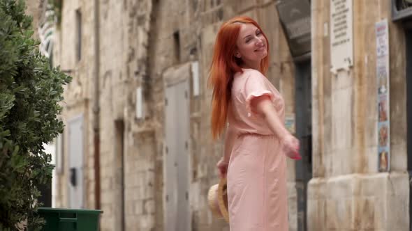 Happy Woman Tourist Laughs and Whirls on Street of Old European City