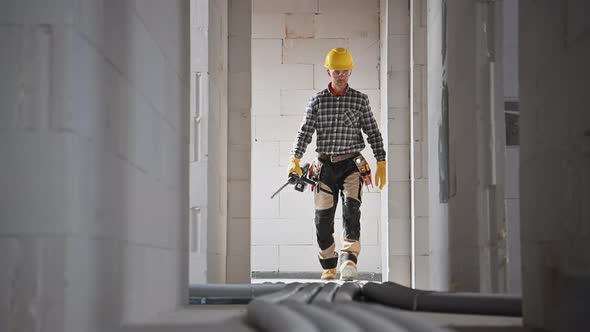 Construction Worker with Power Tool Walking Along Residential Hallway